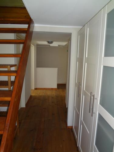 a hallway with a staircase and a room with white cabinets at An Hütten in Herresbach