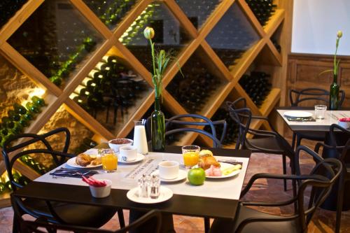 Saint-Martin-du-BoisにあるChateau Prieure Marquetのダイニングルーム(食べ物と飲み物を楽しめるテーブル2台付)