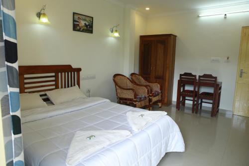 a bedroom with a bed with two towels on it at Anna Residency in Nedumbassery