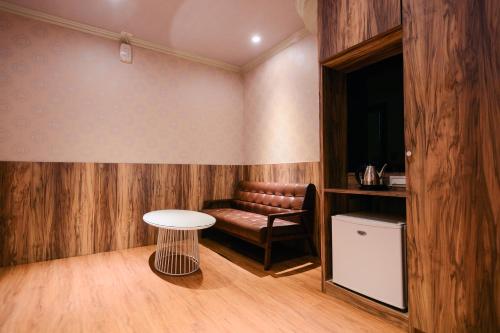 a room with a couch and a table and a stool at Guest Motel- Zhongli Branch in Pingzhen