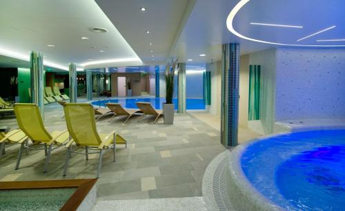 a hotel lobby with a hot tub and chairs at Jankovich Hotel in Rácalmás