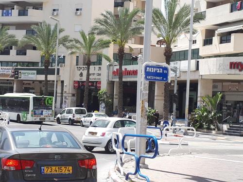 a car parked at a bus stop in a city at Apartment 2 bedrooms Central Location in Ashdod