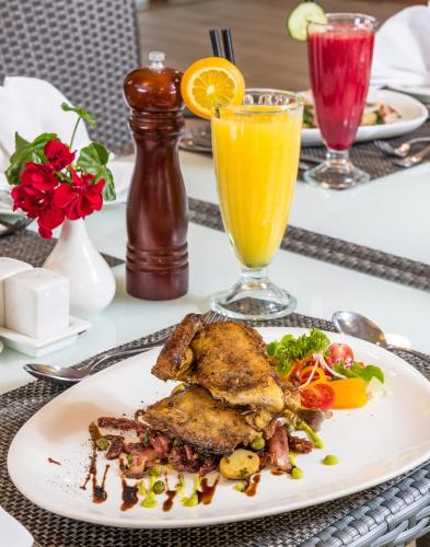 a plate of food with meat and vegetables on a table at Executive Residency by Best Western Nairobi in Nairobi