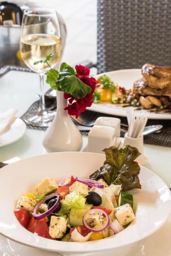 a plate of food on a table with a glass of wine at Executive Residency by Best Western Nairobi in Nairobi