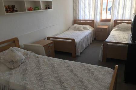 a hotel room with two beds and a window at Spacious chalet in Satellity - Faitroun in Fayţrūn