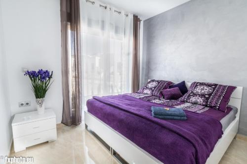 トレビエハにあるELuxuria Sunny Villaのベッドルーム(紫色のベッド1台、窓付)