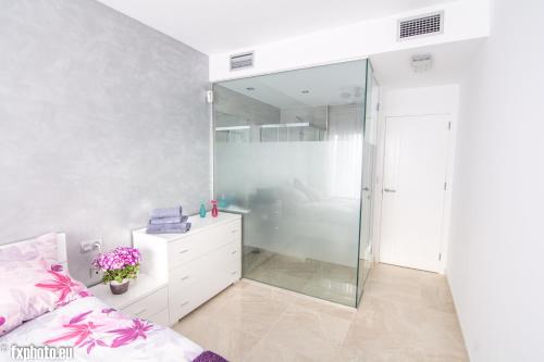 um quarto com uma cabina de duche em vidro e uma cama em ELuxuria Sunny Villa em Torrevieja
