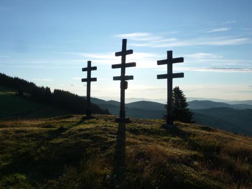 three crosses sitting on top of a hill at Sommeralmhütte in Sankt Kathrein am Offenegg