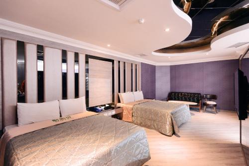 two beds in a room with purple walls at Guest Motel- Zhongli Branch in Pingzhen