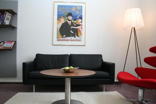 a living room with a black couch and a table at Hotel Koldingfjord in Kolding