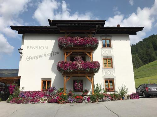 a white building with flower boxes on it at Pension Burgschroffen in Fendels