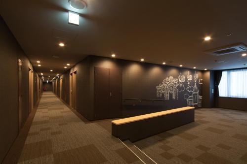 a hallway with a bench and a wall at Izumisano Center Hotel Kansai International Airport in Izumi-Sano