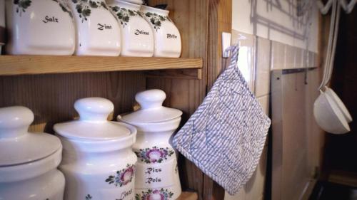 a group of white vases sitting on a shelf at Sommeralmhütte in Sankt Kathrein am Offenegg