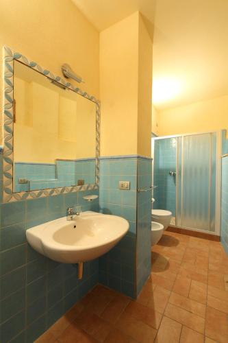 ein Badezimmer mit Waschbecken, Spiegel und zwei Toiletten in der Unterkunft Residence Borgo Da Mare in Monteprandone