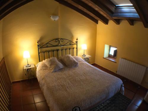 a bedroom with a large bed with two lamps at El Bulin de Horcajuelo in Horcajuelo de la Sierra