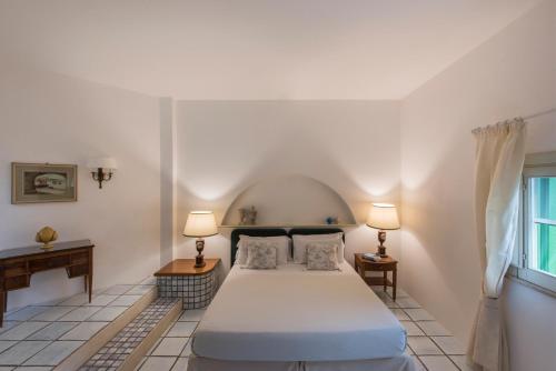 a bedroom with a bed and two lamps and a window at Masseria Il Melograno in Monopoli
