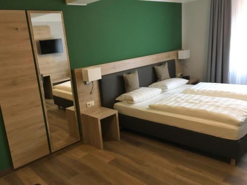 ミュンヘンにあるEberl Hotel Pension München Feldmochingのベッドルーム(大型ベッド1台、鏡付)