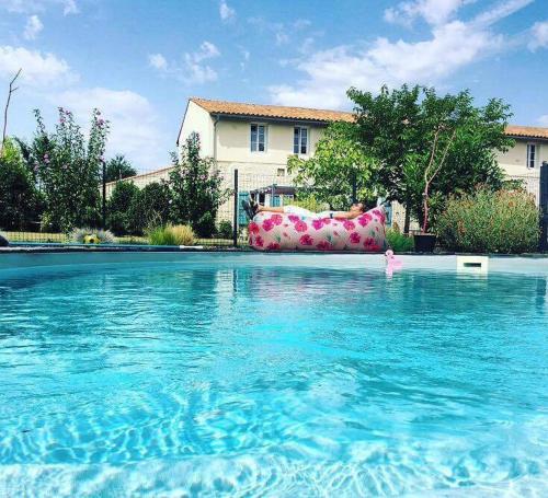 a couch sitting in a swimming pool next to a house at La Chaumeauniere in Aigrefeuille-dʼAunis