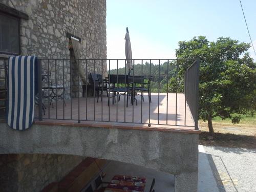 a balcony of a house with a table and chairs at Allotjatments Can Servosa in Sales del Llierca