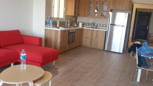 アインソフナにあるTwin House in Telalのキッチン(赤いソファ、テーブル、冷蔵庫付)