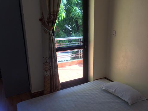 a bedroom with a window with a bed in front of it at Ngan Ha Homestay in Ha Giang