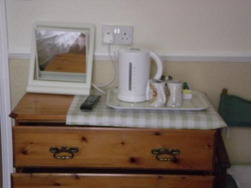 a microwave sitting on top of a wooden dresser at beaufort guesthouse in Weymouth