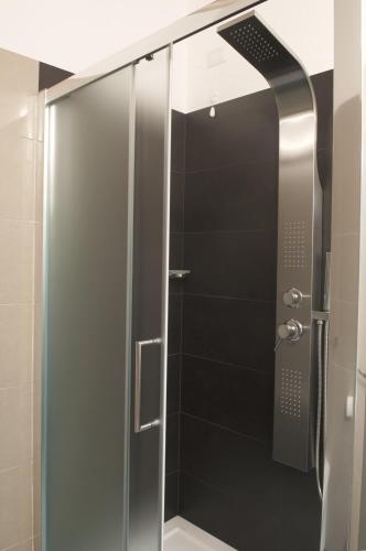 a shower with a glass door in a bathroom at Four Rooms Guesthouse in Oristano