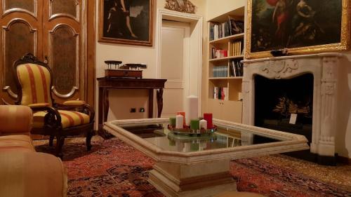 a living room with a fireplace and a table with candles at Gran Suite Piazza Maggiore - T&T communications in Bologna