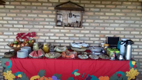 een tafel met eten bovenop een rode tafel bij Oh! Linda Pousada in Redonda