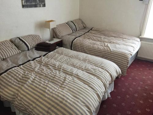 two beds and a couch in a hotel room at The Midway in Blackpool