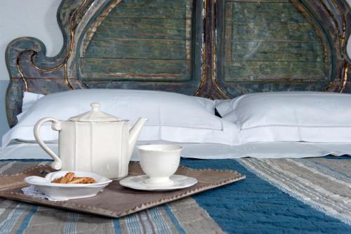 uma bandeja com um conjunto de chá numa cama em La casa di Arianna em Casole dʼElsa