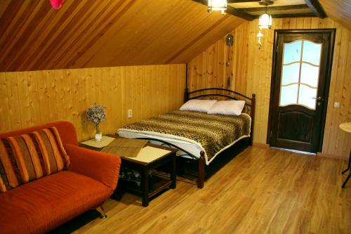エッセントゥキにあるVacation Home on Andzhievskogoのベッドルーム1室(ベッド1台、ソファ、テーブル付)