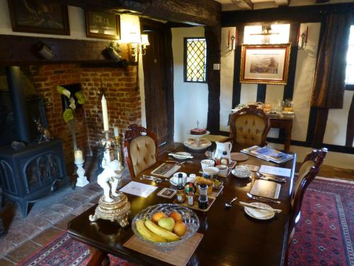 a dining room with a table and a fireplace at The Greyhound - Historic former Inn in Glemsford