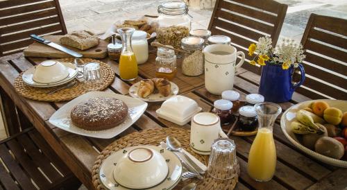 a wooden table with breakfast foods and drinks on it at B&B Sosta A Ponente in Matino