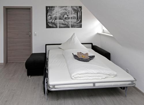 a white bed with a bowl on it in a room at FrankenFeWo in Neusitz