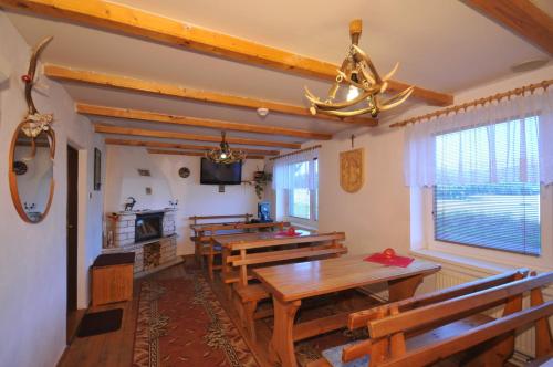 a dining room with wooden tables and benches at Penzion Dreveník in Spišské Podhradie