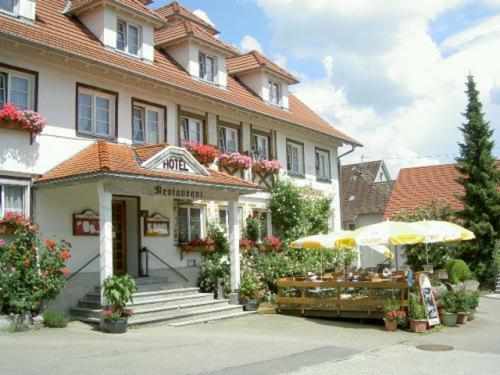 a building with a table and umbrella in front of it at Hotel Restaurant Landhaus Köhle in Neukirch