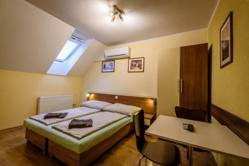 - une chambre avec un lit, un bureau et une table dans l'établissement Apartmany Hujer, à Bojnice