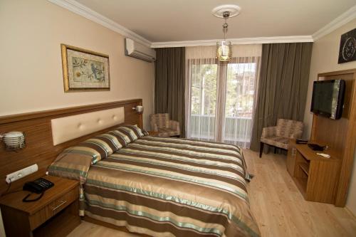 アマスラにあるエミン アパート ペンションのベッドとテレビが備わるホテルルームです。
