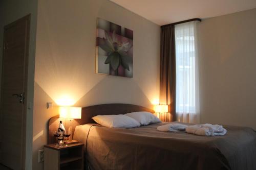 a bedroom with a bed with two towels on it at Dzintars Hotel in Jūrmala