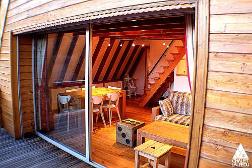 a room with a balcony with a table and chairs at Chalet LALPEDU in L'Alpe-d'Huez