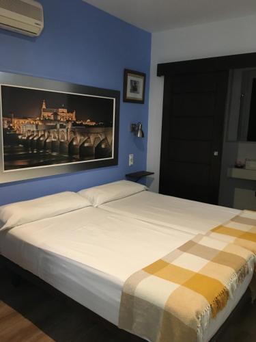 Schlafzimmer mit einem Bett mit Wandgemälde in der Unterkunft Hospederia Alma Andalusi in Córdoba