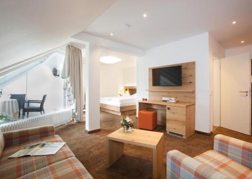 a living room with a couch and a tv at Hotel 3 Könige in Oberwolfach