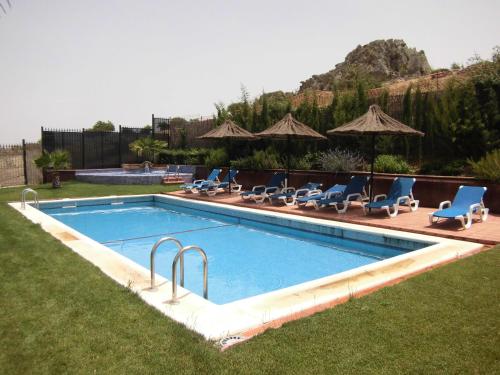 una piscina con tumbonas y una piscina en Hotel Rural Restaurante Los Rosales, en Almadén