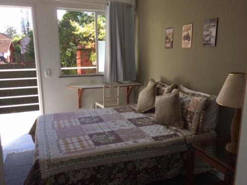 um quarto com uma cama com uma colcha em Pousada HospedaBia em Teresópolis