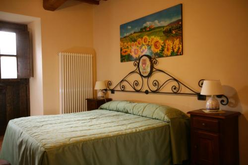 a bedroom with a bed and a painting on the wall at Fonte Chiara in Gubbio