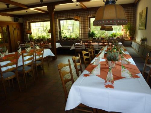 a dining room with white tables and chairs at Hotel Up de Birke in Ladbergen