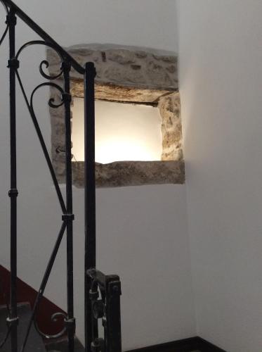 a shelf in the corner of a room with a light at Bomarosa B&B in Bosa