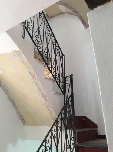 a staircase in a house with an archway at Bomarosa B&B in Bosa