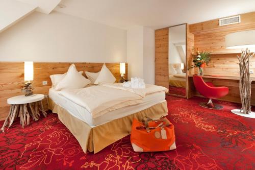 une chambre d'hôtel avec un lit et un tapis rouge dans l'établissement Spa Hôtel Restaurant Au Lion d'Or, à La Petite-Pierre